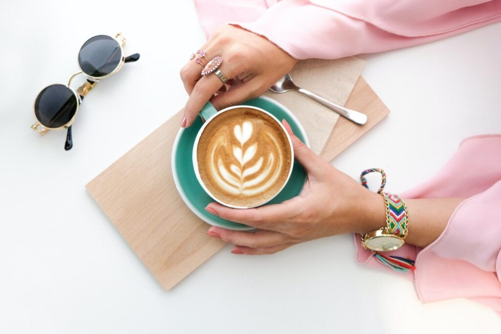 Kvinde sidder med kop kaffe - Kaffes gavnlige effekter | Cuizine